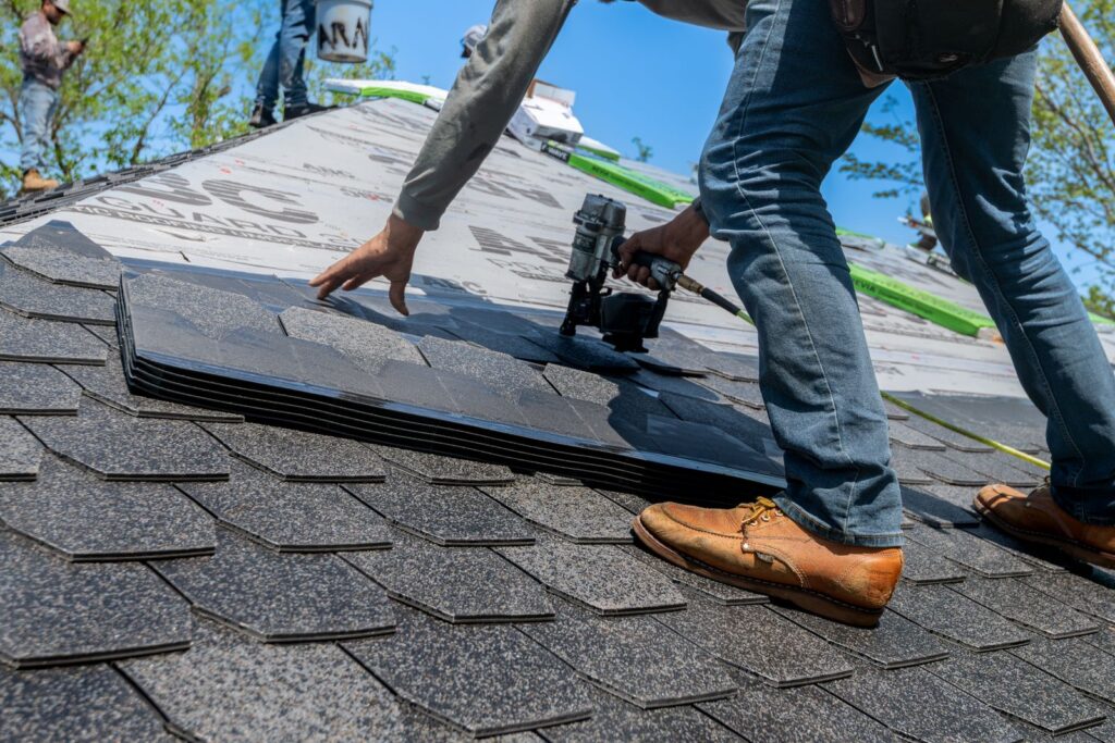 Roofer sealing a shingle roof in Edmond, OK